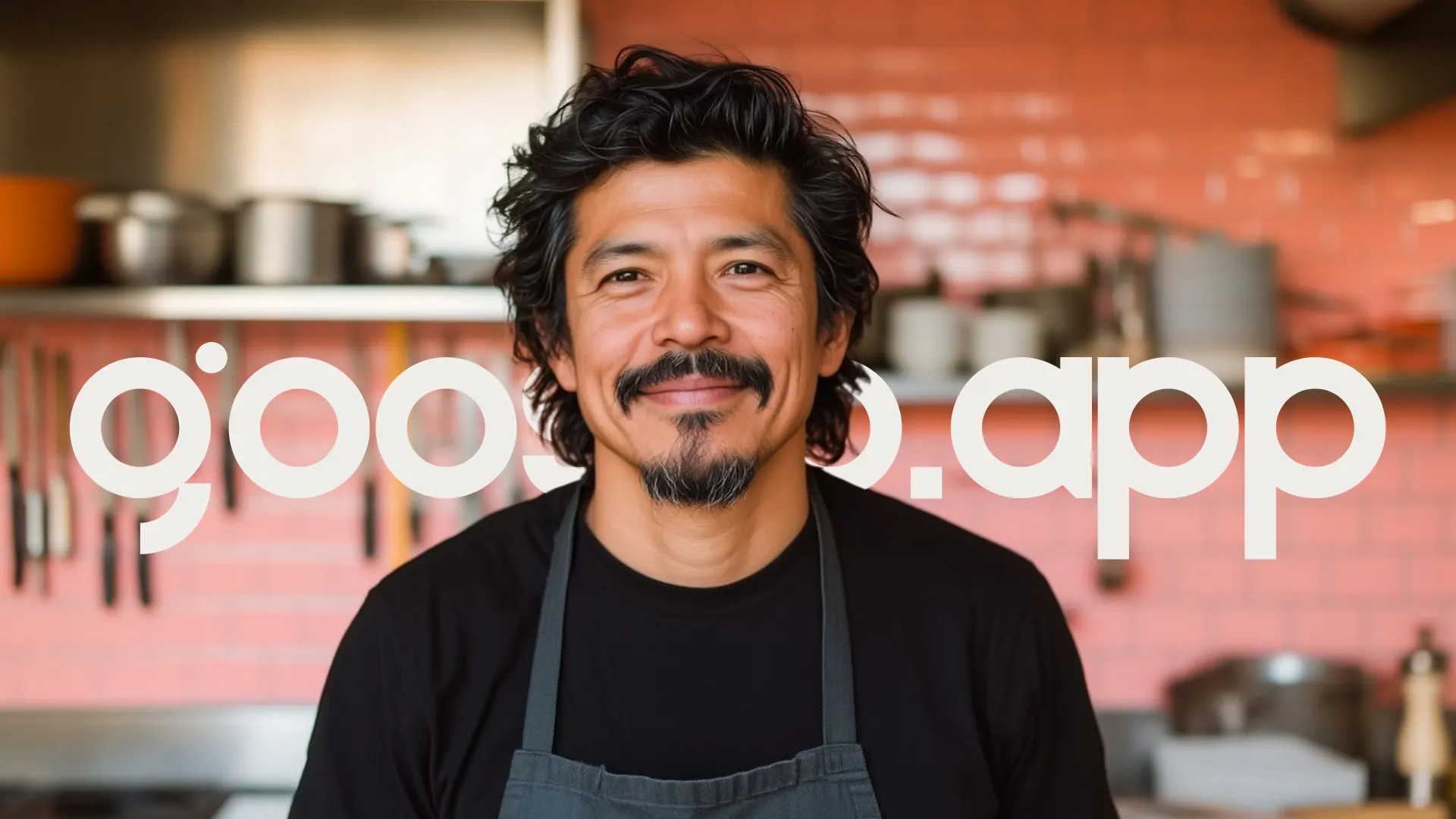 Chef em sua cozinha, com a marca goosto.app em grande escala ao fundo